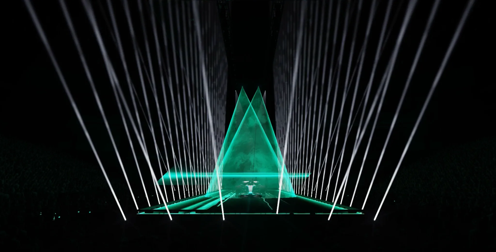 Pre-visualised live production with white lighting beams and a turquoise geometric centrepiece